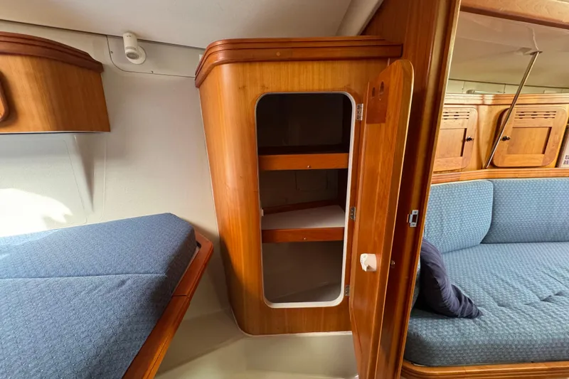 Slide: The Image of Interior of a 2004 C&C 110 sailboat with wooden cabinetry and blue upholstery. - 24