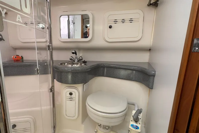 Slide: The Image of Compact bathroom in a 2004 C&C 110 yacht with sink, toilet, and storage cabinets. - 30