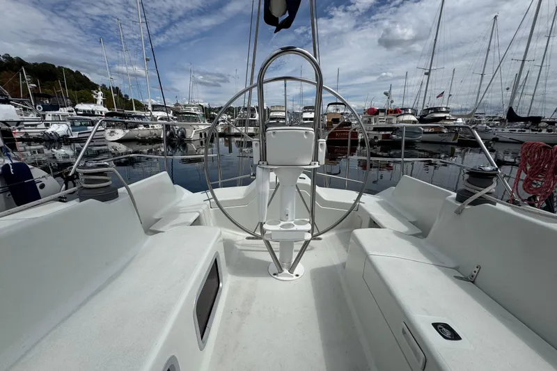 Slide: The Image of Cockpit view of 2004 C&C 110 sailboat docked in a marina under a cloudy sky. - 4