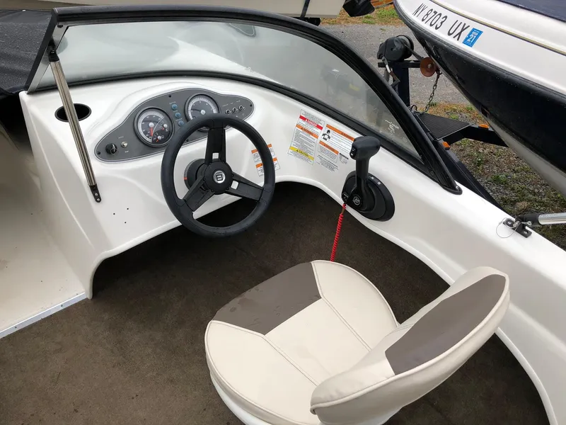 Slide: The Image of 2018 Bayliner 160 Bowrider interior with steering wheel and dashboard controls. - 4