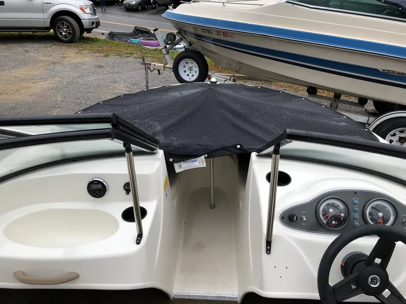 Slide: The Image of 2018 Bayliner 160 Bowrider interior with covered bow, steering wheel, and dashboard controls. - 5