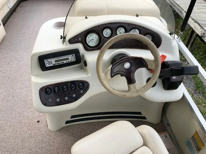 Slide: The Image of 2001 Bennington 2250 RL boat dashboard with steering wheel and control panel. - 6