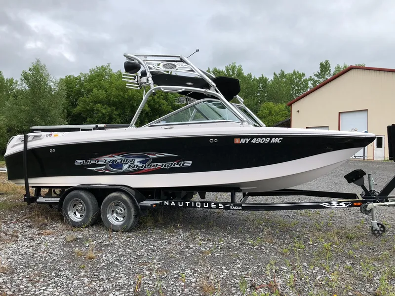 Slide: The Image of 2006 Correct Craft AIR NAUTIQUE 220 boat on trailer, parked outdoors. - 3