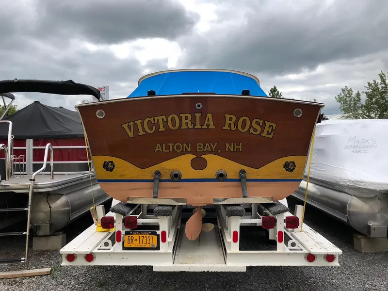 Slide: The Image of 1962 Lyman 245 boat "Victoria Rose" on trailer, Alton Bay, NH, under cloudy sky. - 1