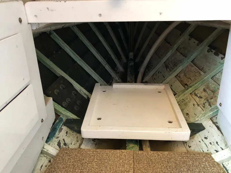 Slide: The Image of Interior view of a 1962 Lyman 245 boat, showcasing wooden framework and storage area. - 12