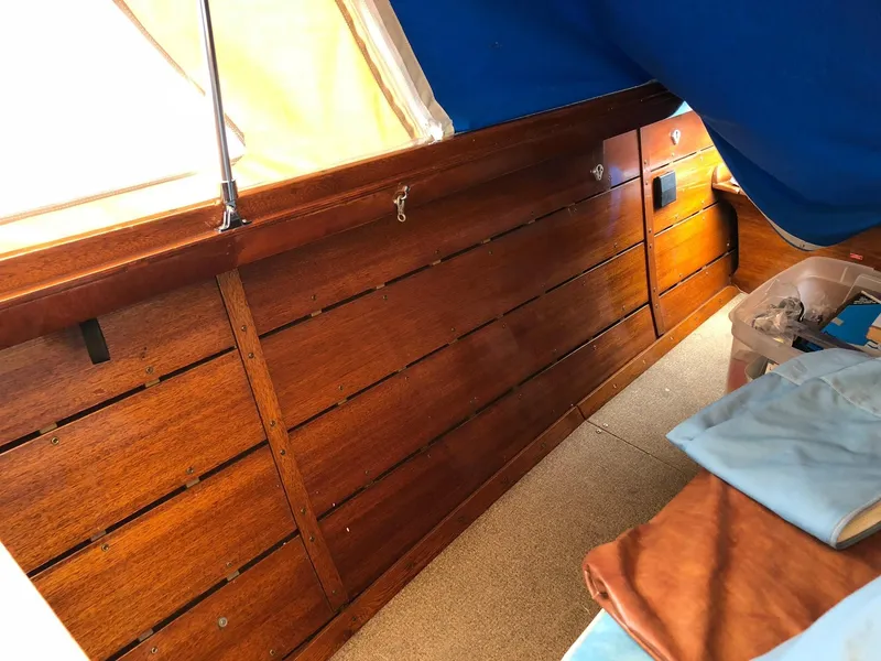 Slide: The Image of Interior of a 1962 Lyman 245 boat with polished wooden paneling and blue fabric. - 14