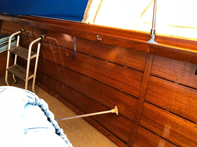 Slide: The Image of Interior of a 1962 Lyman 245 boat with wooden paneling and a metal ladder. - 15