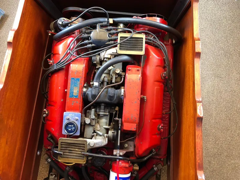 Slide: The Image of 1962 Lyman 245 engine with red components and visible wiring in a wooden compartment. - 16
