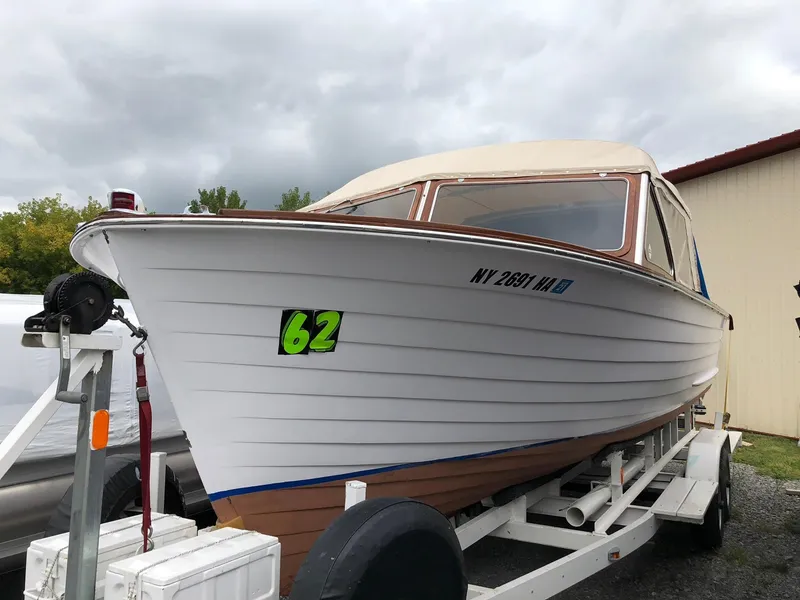 Slide: The Image of 1962 Lyman 245 boat on trailer, white hull, overcast sky background. - 4