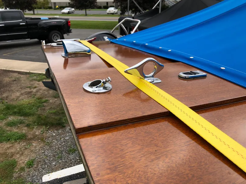 Slide: The Image of 1962 Lyman 245 boat with polished wood deck and blue cover, featuring chrome fittings. - 6