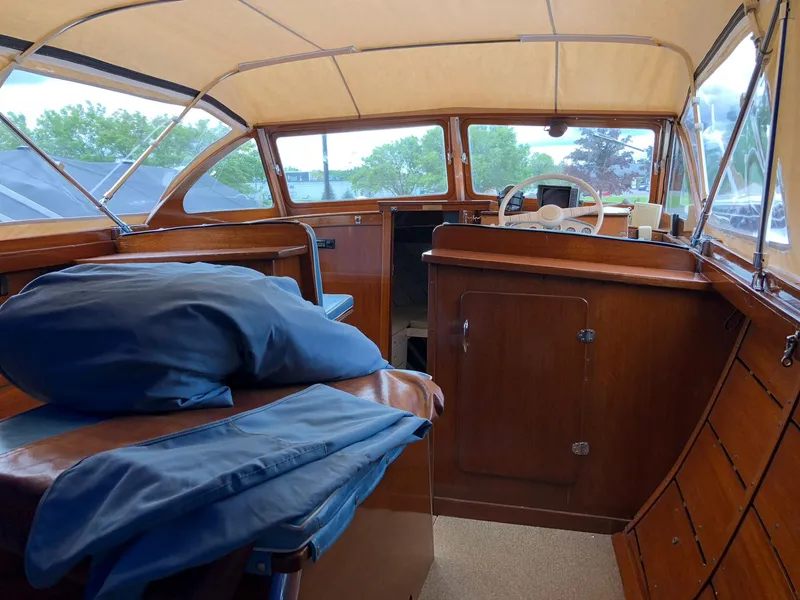 Slide: The Image of Interior of a 1962 Lyman 245 boat with wooden cabinetry and blue cushions. - 7