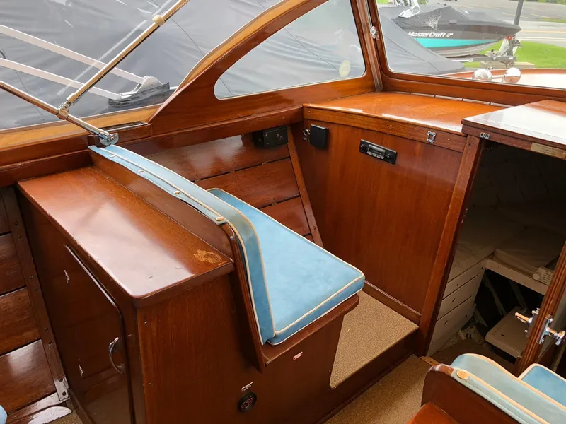 Slide: The Image of Interior of a 1962 Lyman 245 boat with wooden finish and blue seating. - 8