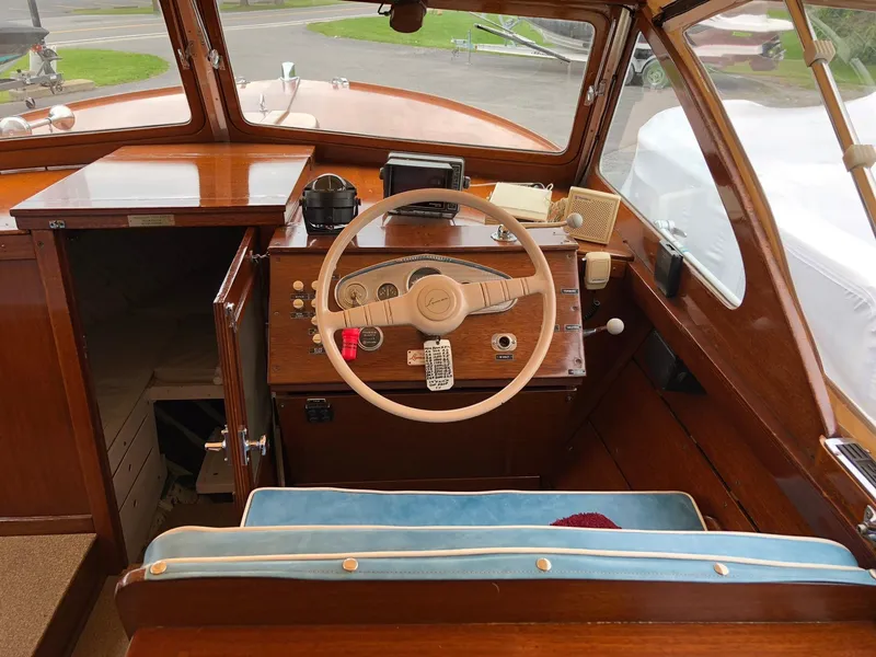 Slide: The Image of 1962 Lyman 245 boat interior with wooden dashboard and steering wheel. - 9