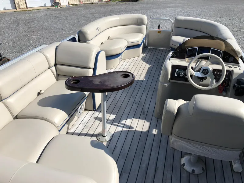 Slide: The Image of 2015 South Bay 522 FCR pontoon boat interior with beige seating and steering console. - 4