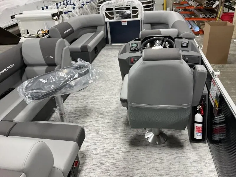 Slide: The Image of 2025 Bennington 20 SL Family pontoon boat interior with privacy room, featuring gray seating and helm. - 19