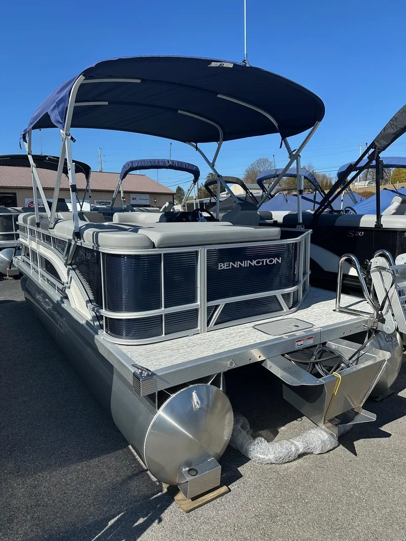 Slide: The Image of 2025 Bennington 20 SL Family pontoon boat with privacy room, docked under blue sky. - 24