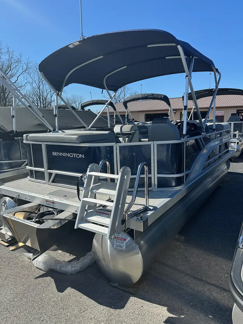 Slide: The Image of 2025 Bennington 20 SL pontoon boat with privacy room, parked outdoors. - 4