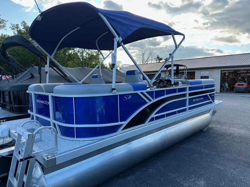 Slide: The Image of 2025 Bennington 21 SSR Quad Bench pontoon boat with blue canopy, in stock. - 16