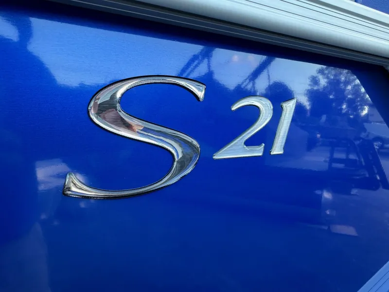 Slide: The Image of Close-up of 2025 Bennington 21 SSR Quad Bench logo on blue surface. - 2