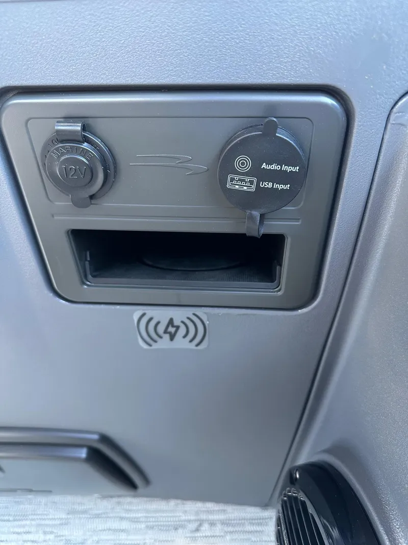 Slide: The Image of 2025 Bennington 21 SSR Quad Bench console with 12V, audio, USB inputs, and wireless charging. - 22