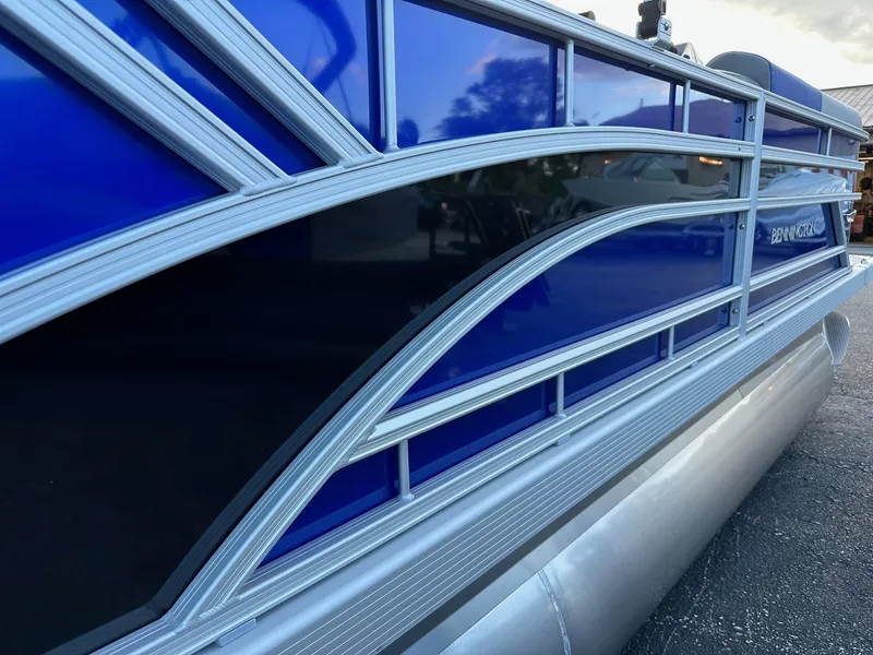 Slide: The Image of 2025 Bennington 21 SSR Quad Bench pontoon boat with sleek blue and silver design. - 3