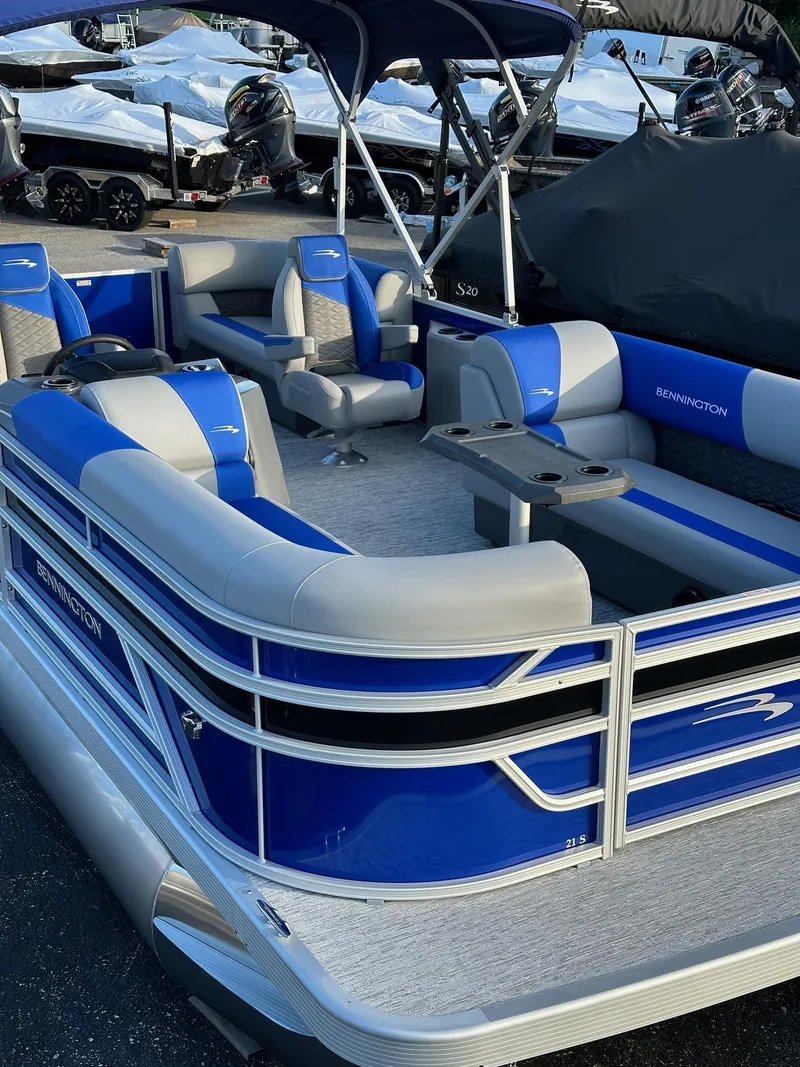 Slide: The Image of 2025 Bennington 21 SSR Quad Bench pontoon boat with blue and gray seating. - 33