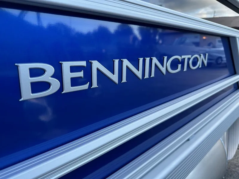 Slide: The Image of Close-up of 2025 Bennington 21 SSR Quad Bench boat logo on blue surface. - 4