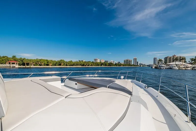 Slide: The Image of 2023 Galeon 680 Fly yacht cruising on a sunny day with city skyline in the background. - 18