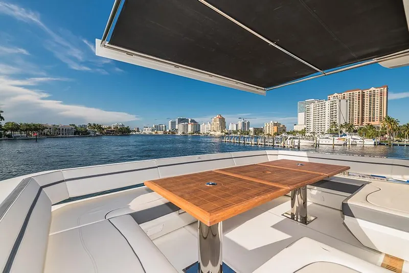 Slide: The Image of Luxury deck view on the 2023 Galeon 680 Fly yacht, overlooking a scenic waterfront cityscape. - 26