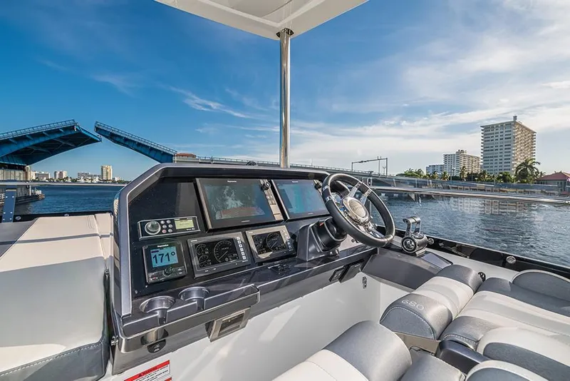 Slide: The Image of Cockpit view of 2023 Galeon 680 Fly yacht with bridge and cityscape in background. - 28