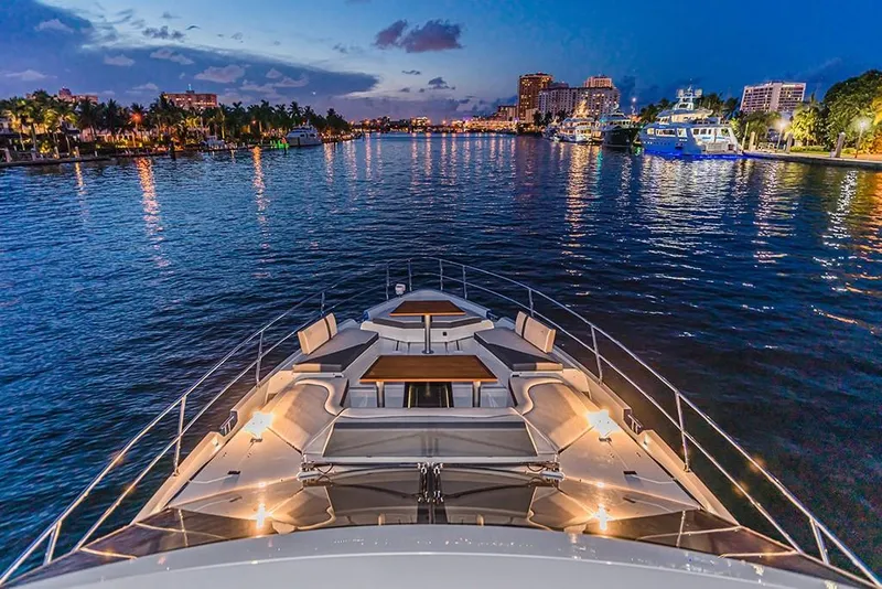 Slide: The Image of 2023 Galeon 680 Fly yacht cruising at dusk in a city harbor. - 36