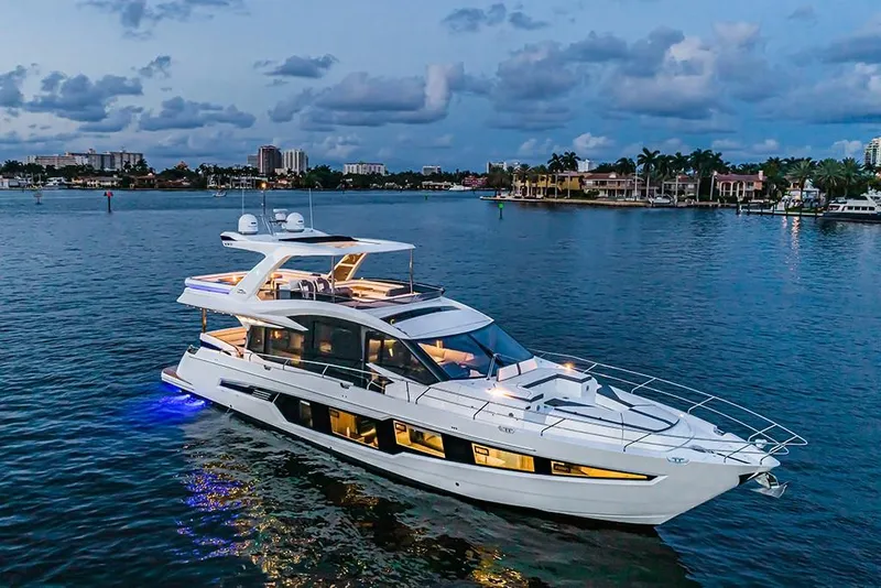 Slide: The Image of 2023 Galeon 680 Fly yacht cruising on a serene waterway at dusk. - 9