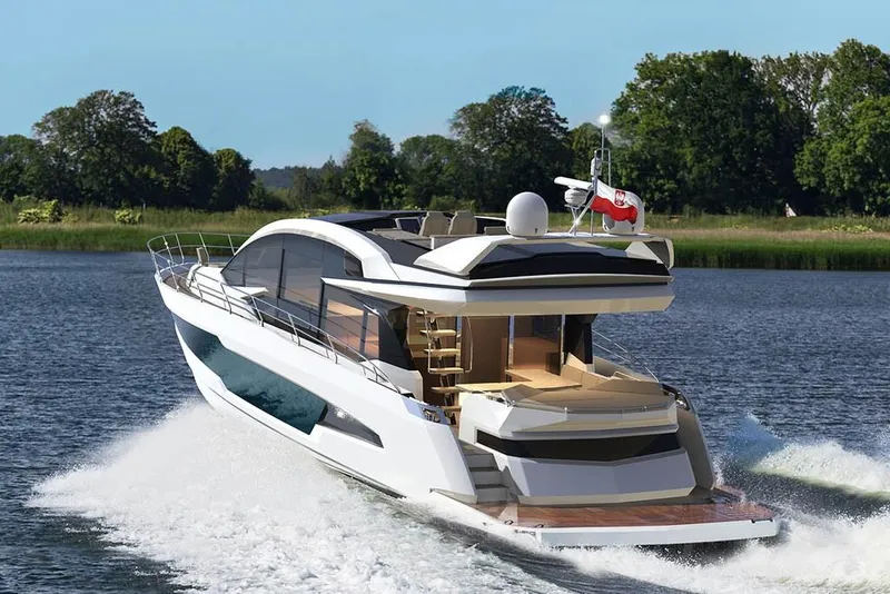 Slide: The Image of 2023 Galeon 700 Sky yacht cruising on a lake with lush green trees in the background. - 3