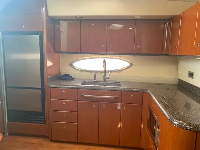 Slide: The Image of 2009 Formula 45 Yacht kitchen with wood cabinets, stainless steel appliances, and oval window. - 20