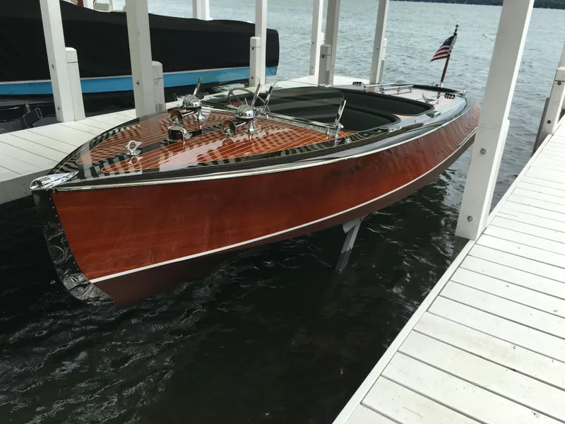 Slide: The Image of 1940 Chris-Craft Deluxe Runabout boat docked on water, showcasing classic wooden design. - 0