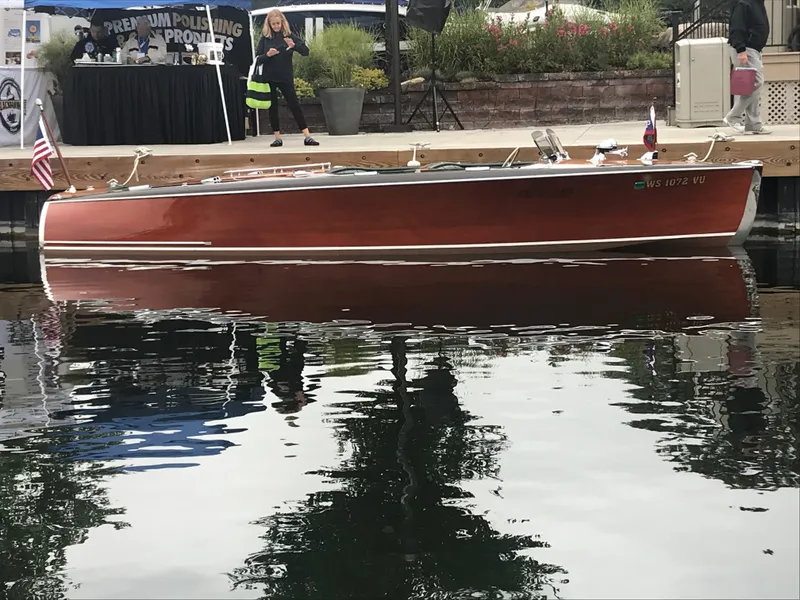 Slide: The Image of 1940 Chris-Craft Deluxe Runabout boat docked, reflecting on calm water. - 3