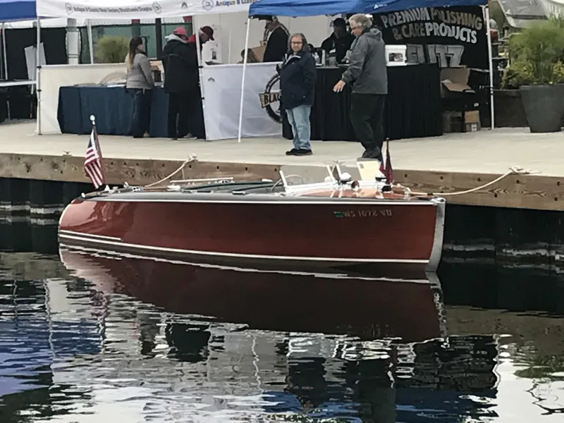 Slide: The Image of 1940 Chris-Craft Deluxe Runabout boat docked at a waterfront event. - 5