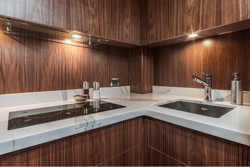 Slide: The Image of Modern kitchen in 2022 Hatteras GT45X Open yacht with wood cabinetry and sleek countertops. - 8