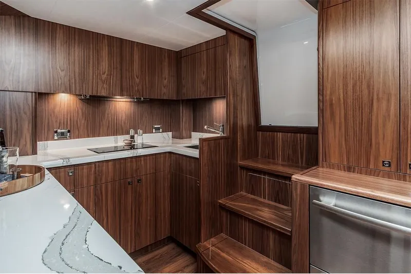 Slide: The Image of 2022 Hatteras GT45X Open yacht interior kitchen with modern wood cabinetry and sleek countertops. - 9