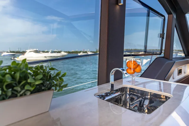 Slide: The Image of Galeon 425 HTS 2023 yacht interior with sink, plant, and ocean view. - 13