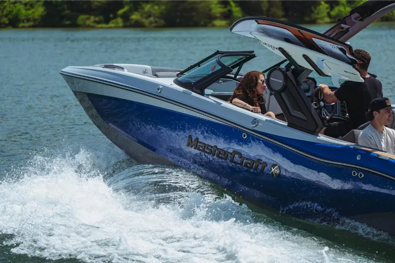Slide: The Image of 2023 MasterCraft X22 boat cruising on a lake with passengers. - 1