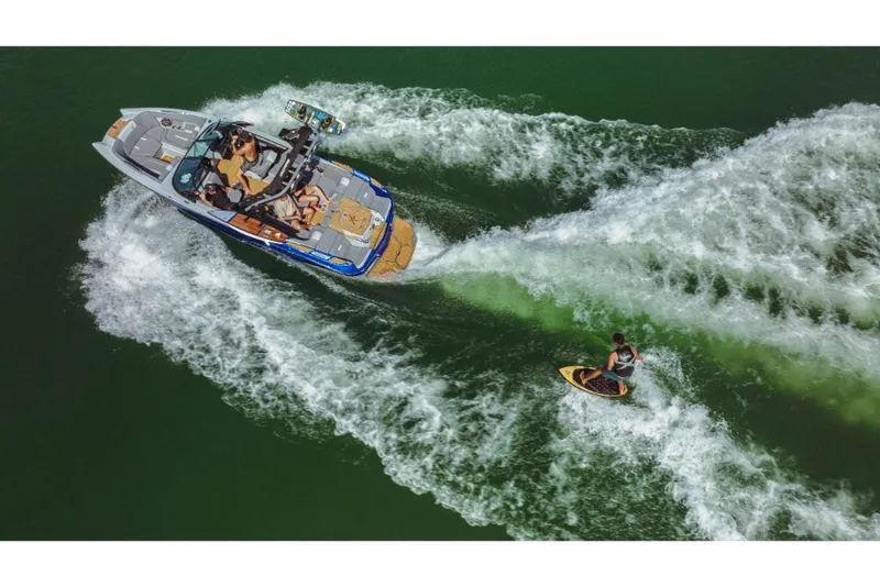Slide: The Image of 2023 MasterCraft X22 boat towing a wakeboarder on a lake. - 3