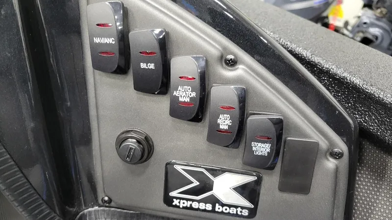Slide: The Image of Control panel of 2025 Xpress X21 Pro Bass boat with labeled switches. - 23