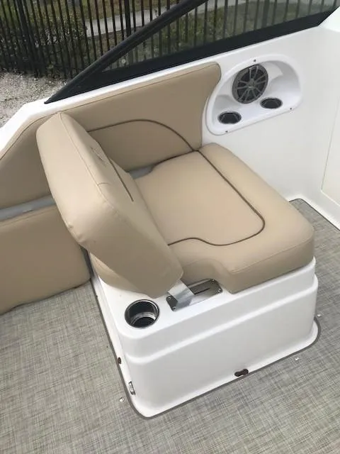 Slide: The Image of 2019 NauticStar 2302 LDC boat seat with beige upholstery and cup holder. - 11