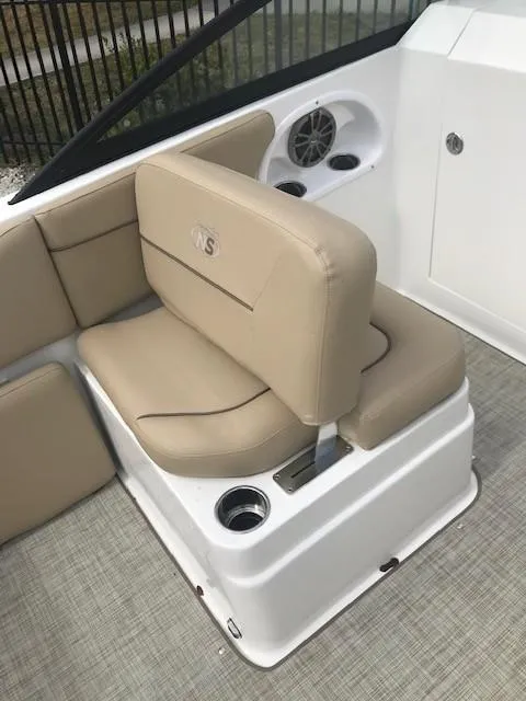 Slide: The Image of 2019 NauticStar 2302 LDC boat interior with beige seating and cup holders. - 12