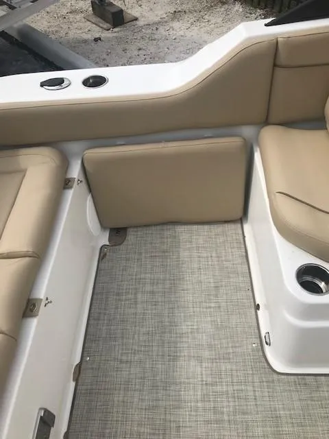Slide: The Image of 2019 NauticStar 2302 LDC boat interior with beige seating and carpeted floor. - 13