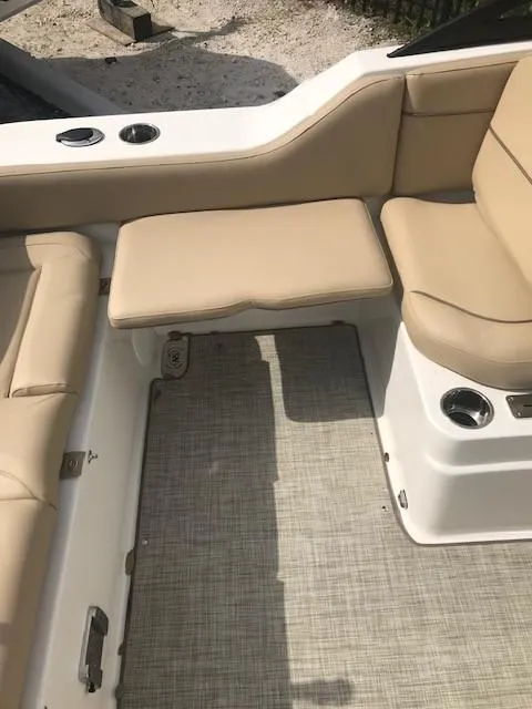 Slide: The Image of 2019 NauticStar 2302 LDC boat interior with beige seating and textured flooring. - 14