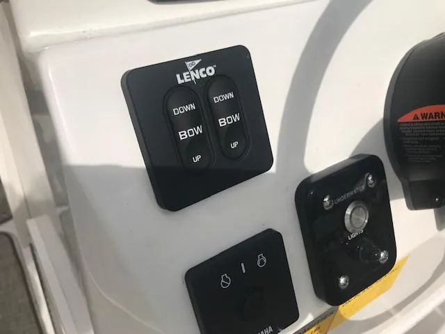 Slide: The Image of Close-up of 2019 NauticStar 2302 LDC boat controls, featuring Lenco trim tab switches. - 19