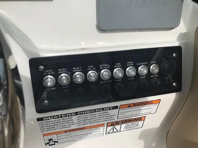 Slide: The Image of Control panel of 2019 NauticStar 2302 LDC boat with switches and safety warnings. - 20