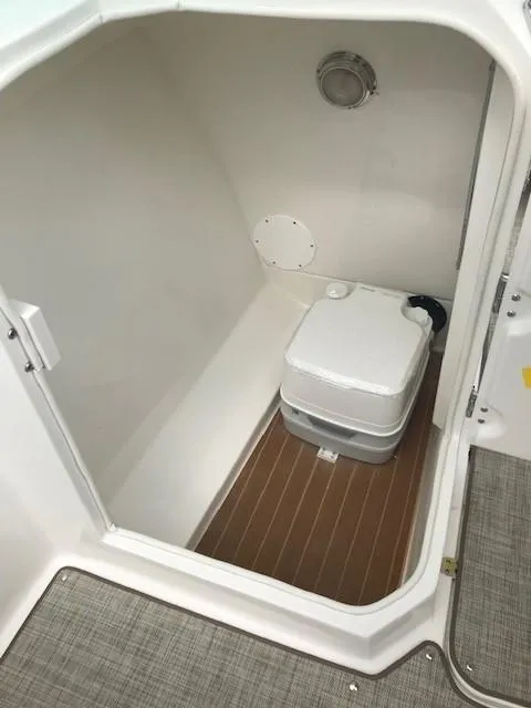 Slide: The Image of 2019 NauticStar 2302 LDC boat interior with portable toilet. - 24